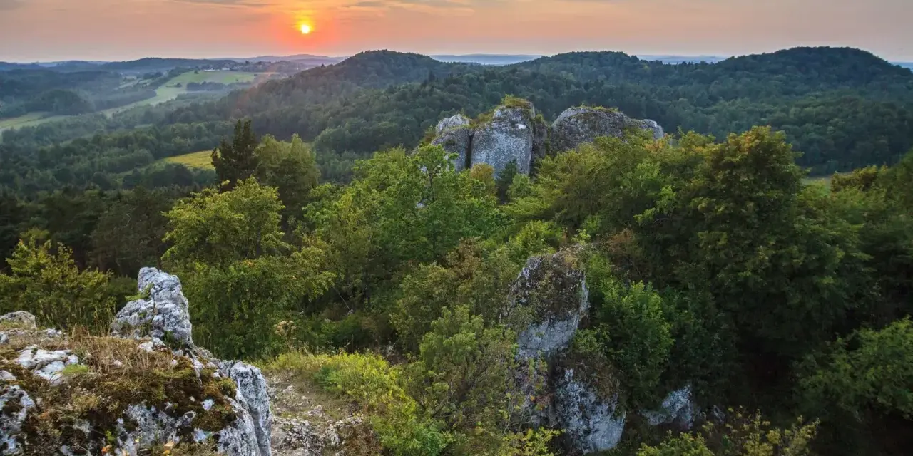 Zachód słońca nad Górami Świętokrzyskimi. Skaliste formacje i bujna zieleń tworzą malownicze krajobrazy, jedne z wielu atrakcji regionu.
