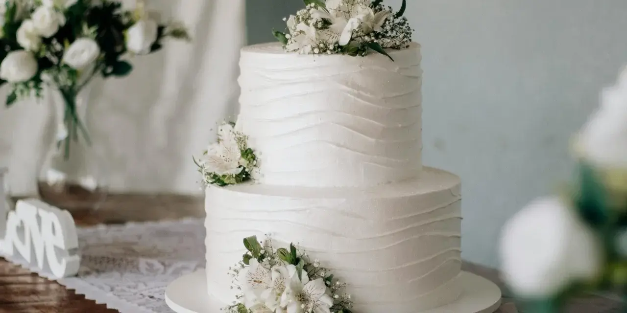 Elegancki tort weselny ozdobiony kwiatami, idealny na ślub cywilny. Piękne życzenia na ślub cywilny dla Młodej Pary.
