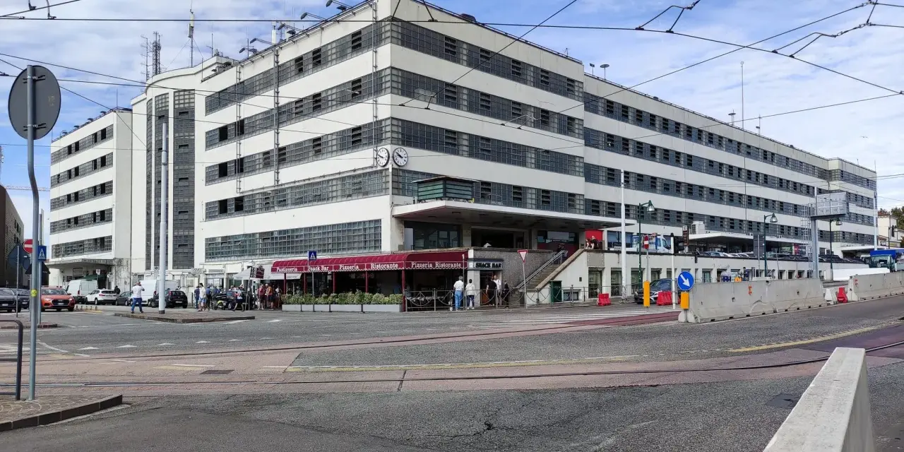 Edificio moderno con finestre a griglia, ideale per chi cerca dove parcheggiare a Venezia. Si intravedono locali commerciali e traffico.