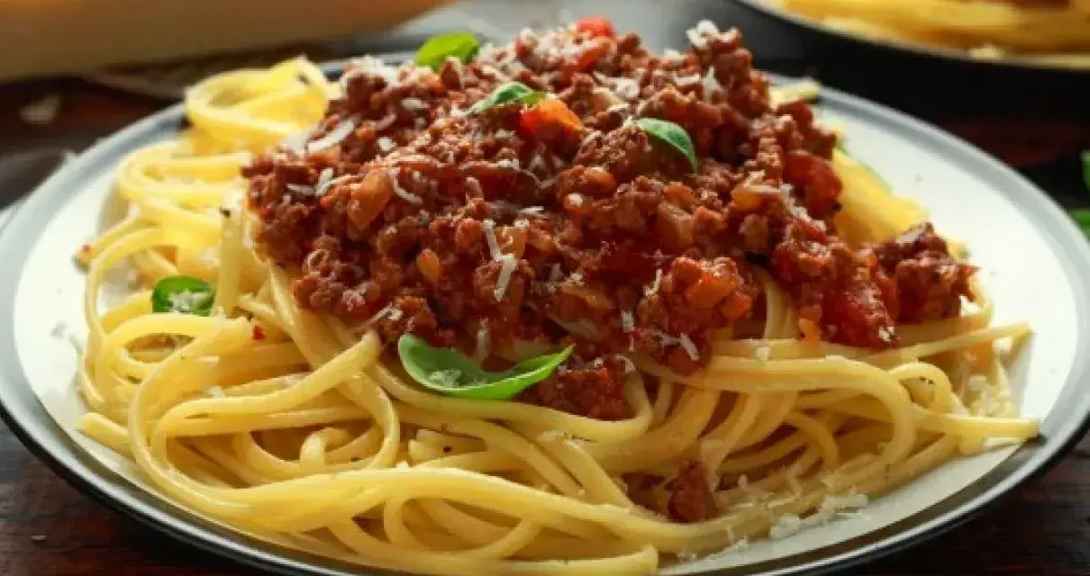 Pyszne spaghetti bolognese z mielonym mięsem, pomidorami i bazylią. Idealne przyprawy do spaghetti podkreślają smak dania.