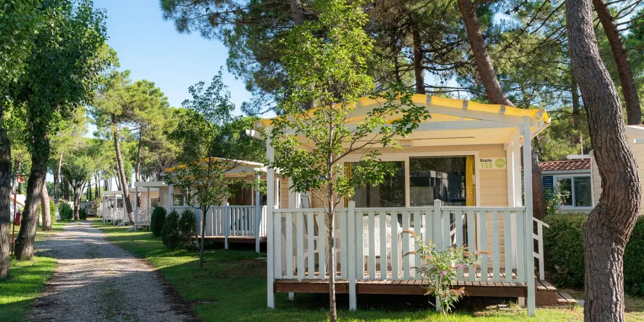 Uroczy camping Rialto z domkami letniskowymi w otoczeniu drzew.