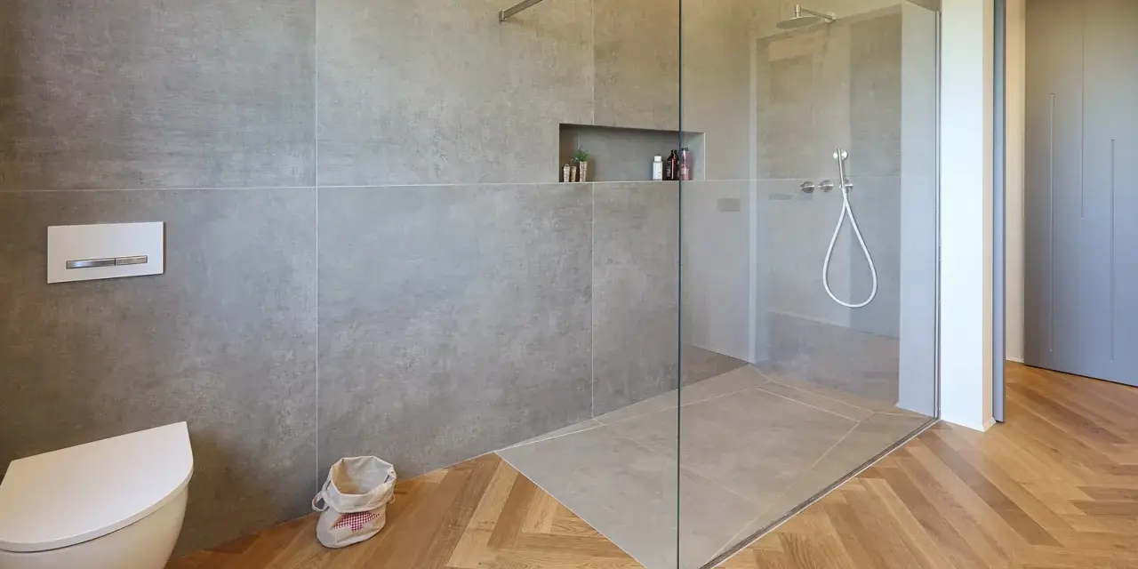 Bagno moderno con doccia walk-in, vaso sospeso e finiture in legno. Il significato di doccia walk-in è uno spazio aperto e accessibile.