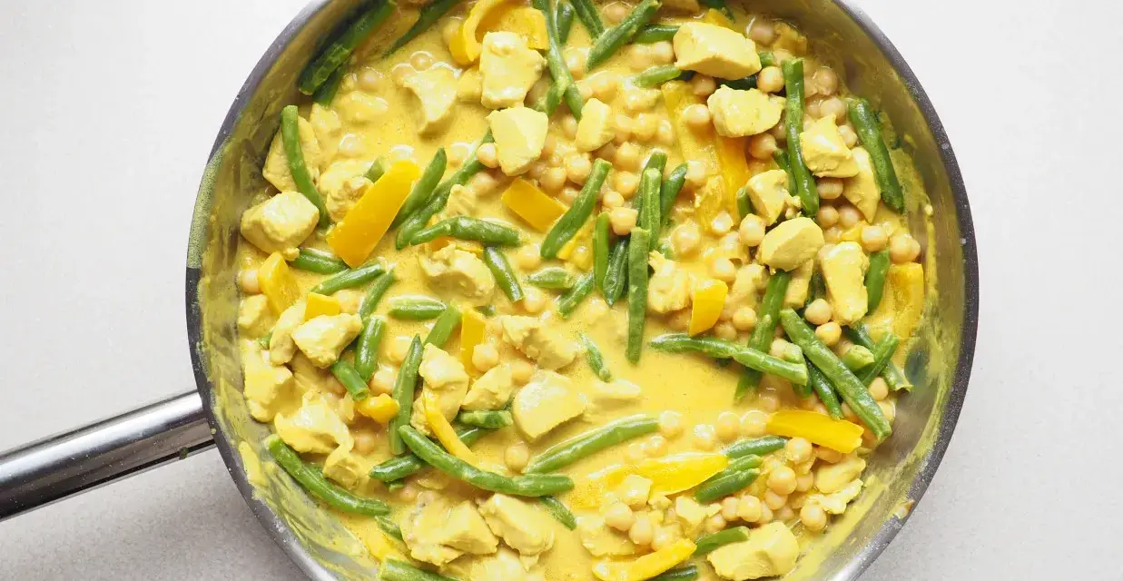 Pyszne danie curry z kurczakiem, fasolką szparagową i ciecierzycą w kremowym sosie.