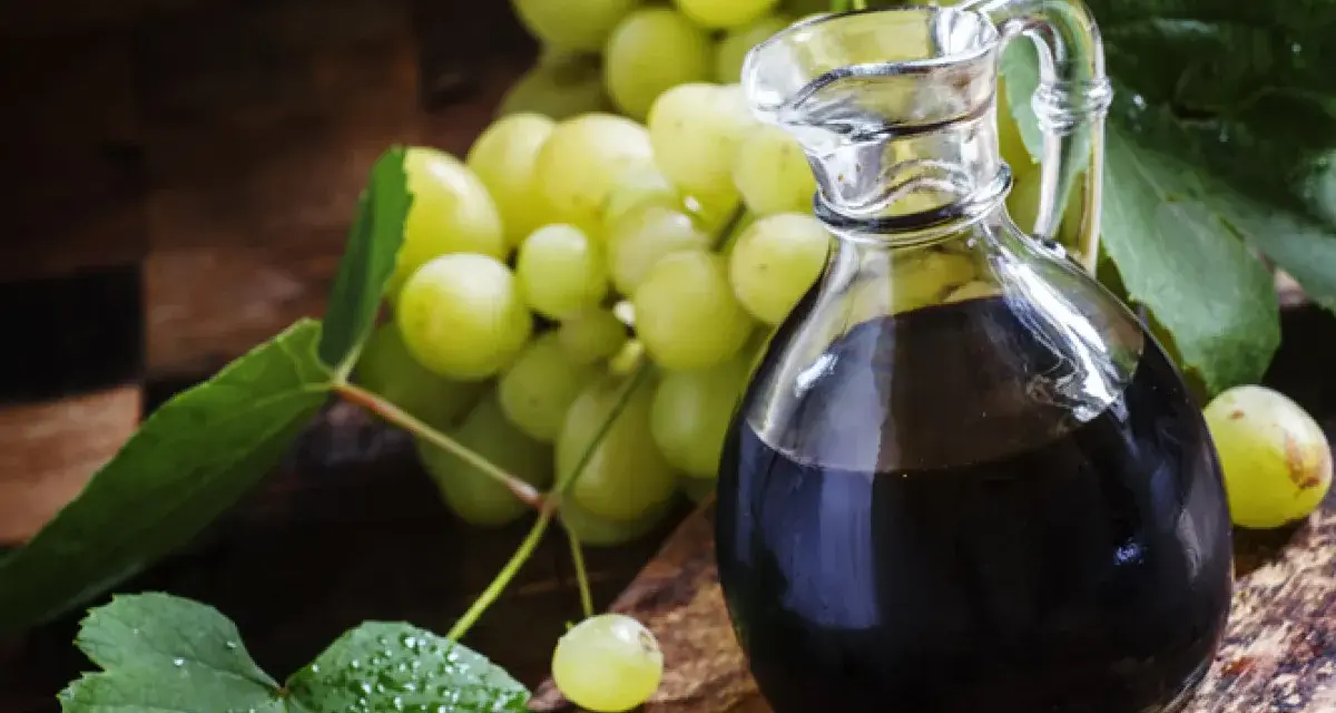 Ciemny płyn w karafce i winogrona. Szukasz, czym zastąpić ocet balsamiczny? Oto inspiracja.