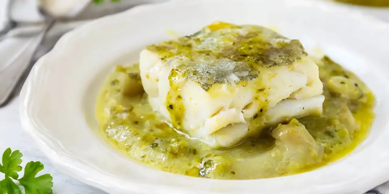 Un trozo de merluza a la vasca, jugoso y tierno, bañado en una salsa verde cremosa con trozos de pimiento.