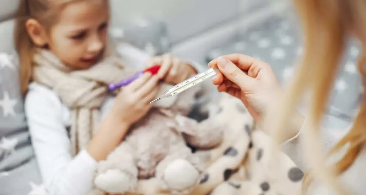 Chora dziewczynka z gorączką, mama mierzy temperaturę. Czy to rotawirus?