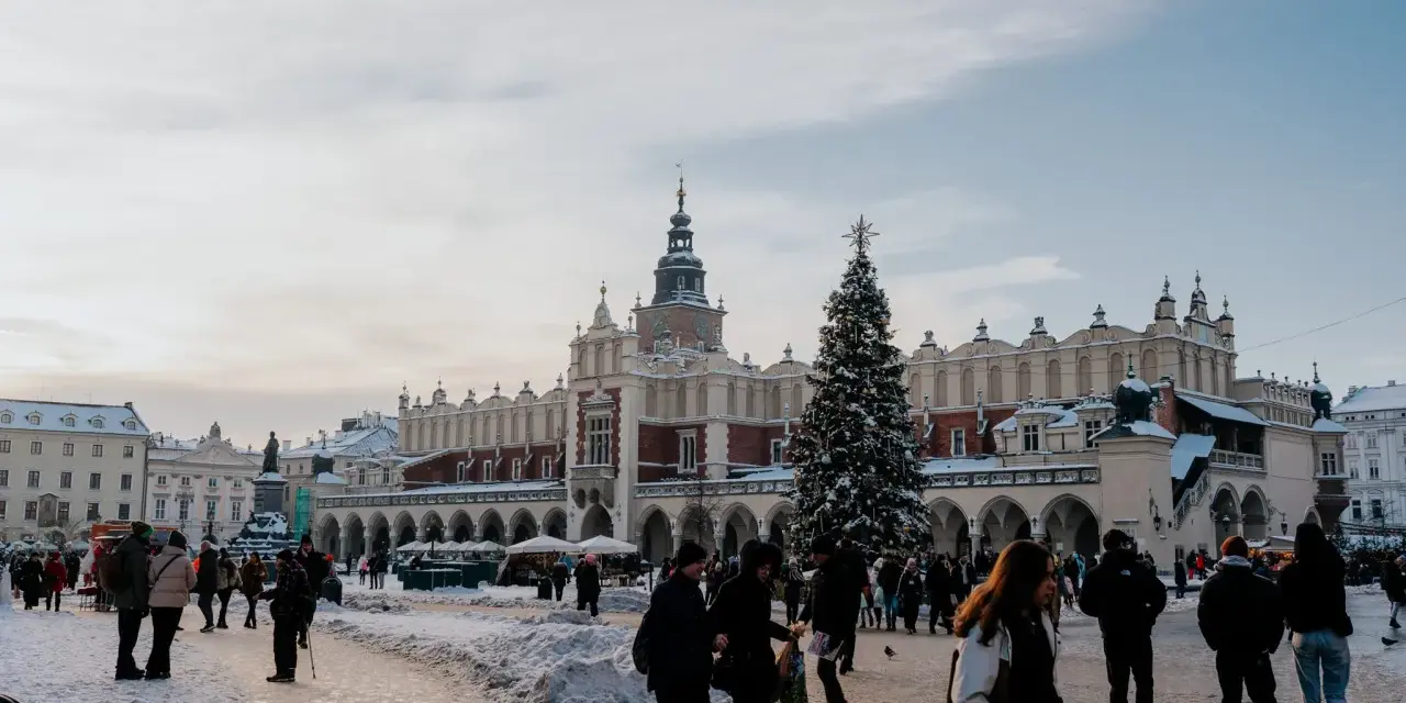 Zimowy Rynek Główny w Krakowie z Sukiennicami i choinką. Spacer po Rynku to jedne z darmowych atrakcji Krakowa, nawet w śnieżny dzień.
