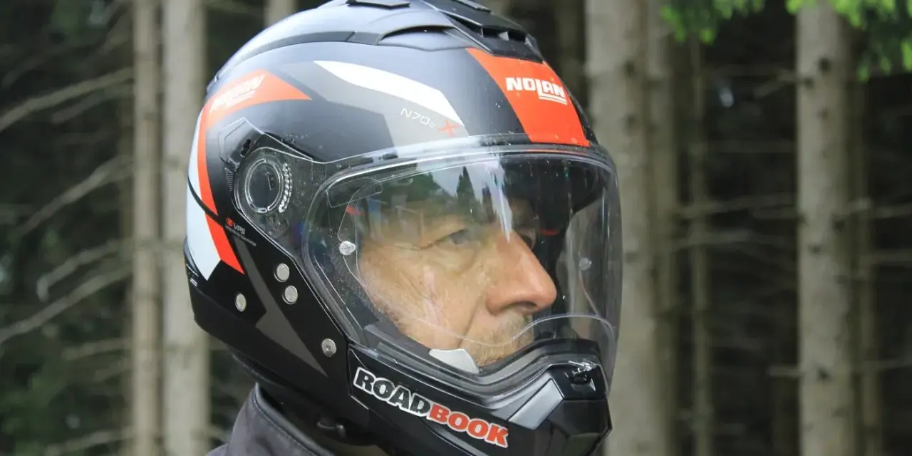 Uomo con casco Nolan, simbolo di sicurezza e avventura su due ruote. Il suo significato è protezione per ogni viaggio.
