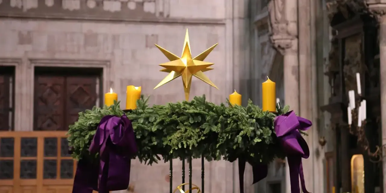 Ein Adventskranz mit vier gelben Kerzen und einem goldenen Stern, geschmückt mit lila Bändern. Seine Bedeutung liegt im Warten und Hoffen auf Weihnachten.