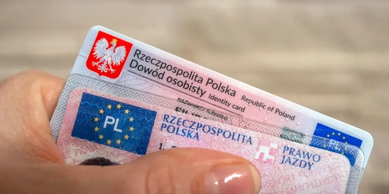 Dłoń trzyma polski dowód osobisty i prawo jazdy. To dokumenty, które pozwalają na swobodne podróżowanie, a prawo jazdy bezterminowe daje spokój na lata.