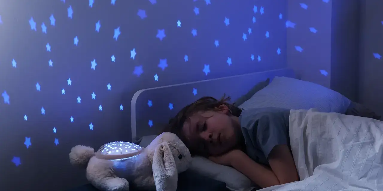 Uroczy króliczek z projektorem dla niemowlaka rzuca na ścianę niebieskie gwiazdki, tworząc magiczną atmosferę do snu.