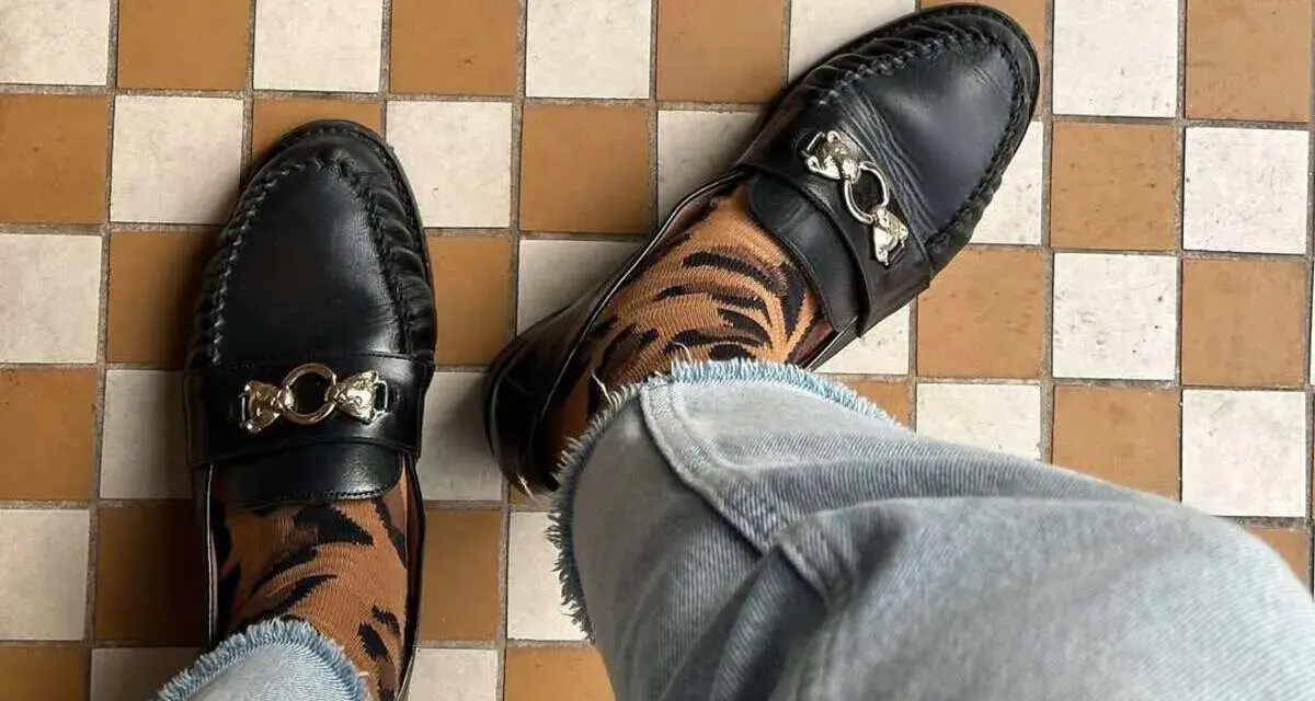 Elegantes mocasines negros con detalle de tigre en los calcetines, un ejemplo de los diversos tipos de mocasines.