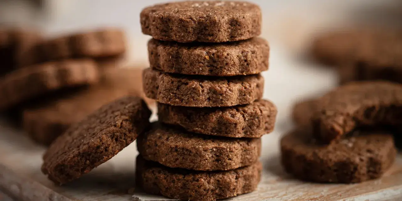 Stack of chocolate biscotti on a wooden board.