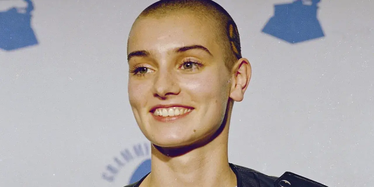 Uśmiechnięta Sinéad O'Connor z ogoloną głową, w czarnej ramonesce. Jej spojrzenie mówi, że nic nie porównuje się do Ciebie.