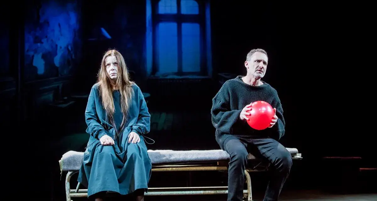 Agata Kulesza w teatrze, siedzi obok mężczyzny z czerwoną piłką.