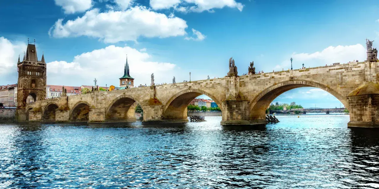 Most znany z atrakcji Czech, Most Karola w Pradze, z wieżą i rzeką Wełtawą.