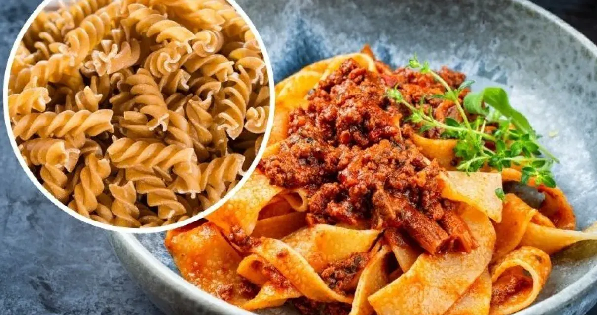 Pyszny makaron na redukcji z sosem bolognese. Widać też surowy makaron fusilli, idealny do zdrowych posiłków.