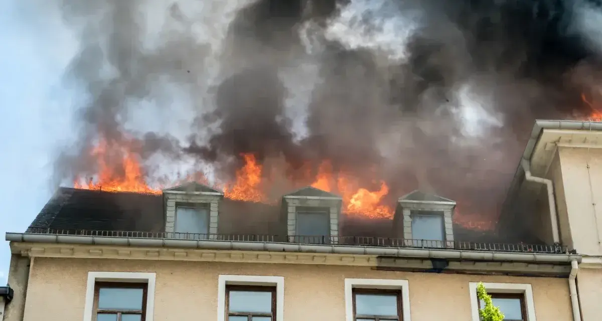 Dachstuhlbrand mit Flammen und schwarzem Rauch. Ein trauriger Nachweis, warum eine Hausratversicherung wichtig ist.