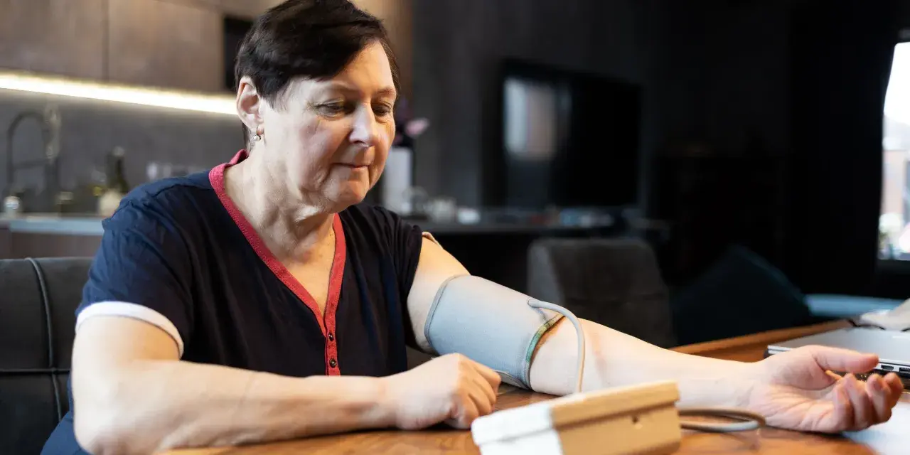 Kobieta mierzy ciśnienie. Zastanawia się, jakie ciśnienie jest niebezpieczne dla jej zdrowia.