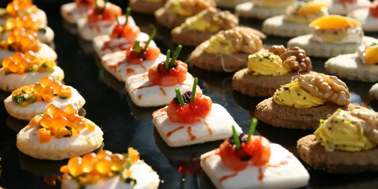 Varietà di finger food da fare in anticipo: tartine con salmone, gamberetti, uova di pesce e noci. Perfetti per ogni occasione.