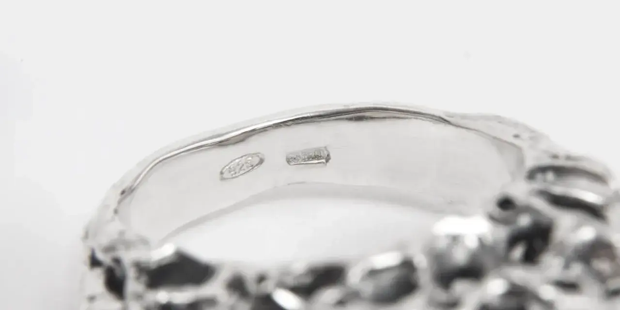 Anello in argento con incisione "925". Un numero argento e oro che brilla.