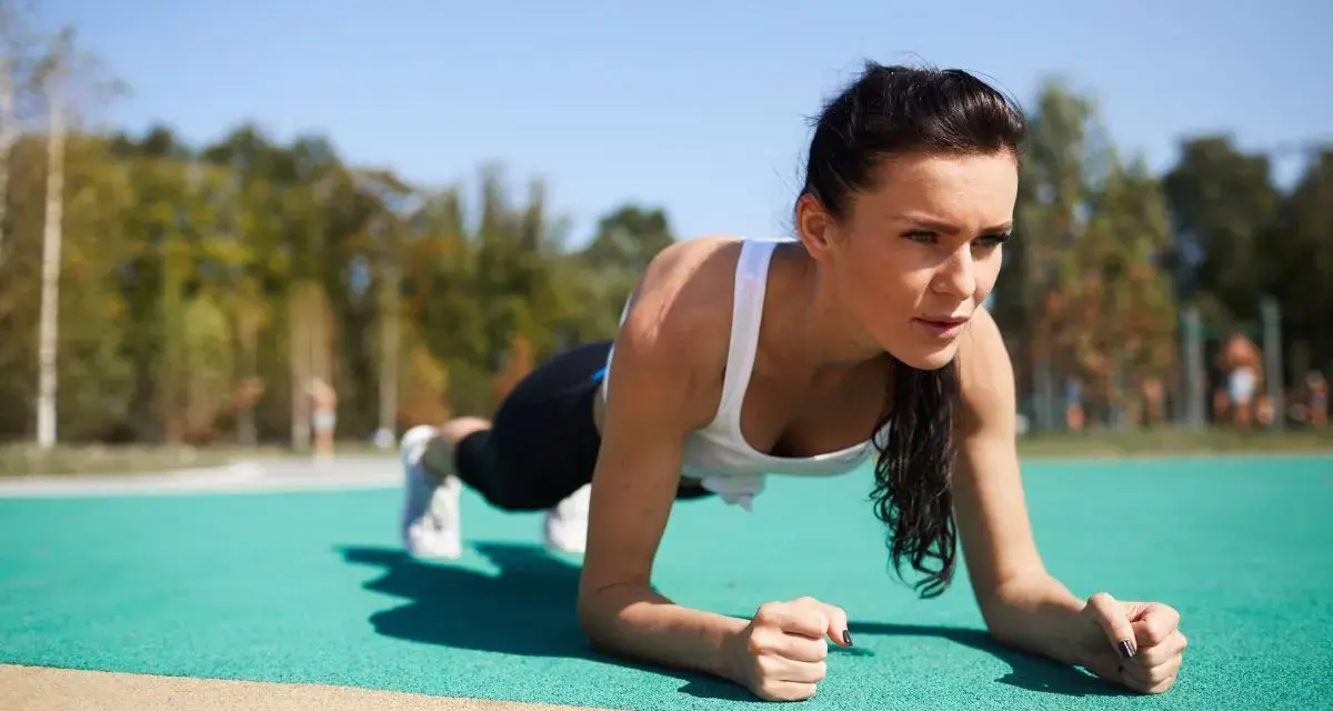 Kobieta wykonuje plank, idealne ćwiczenie na trening core dla początkujących.