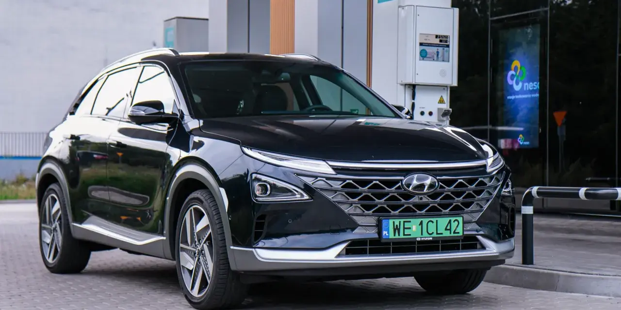 Czarny Hyundai Nexo, jeden z samochodów na wodór, tankuje na stacji.