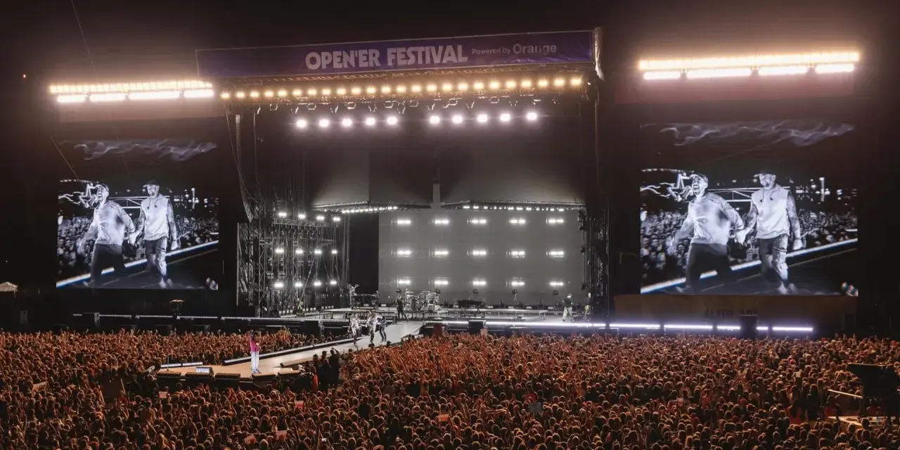 Ogromny tłum na Opener Festival, **ile ludzi**! Na scenie artyści, a na telebimach ich wizerunki.