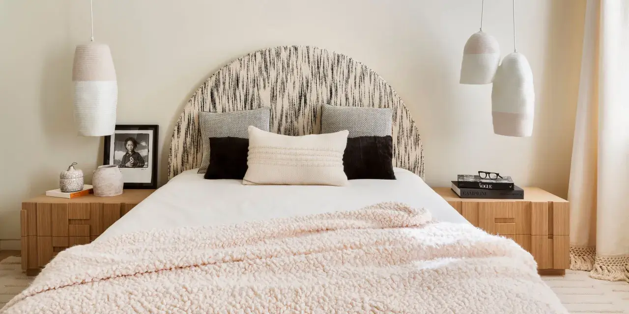 Camera da letto con testiera a semicerchio, cuscini decorativi e coperta rosa. Lampade a sospensione e comodini in legno completano l'arredamento, creando camere aesthetic.