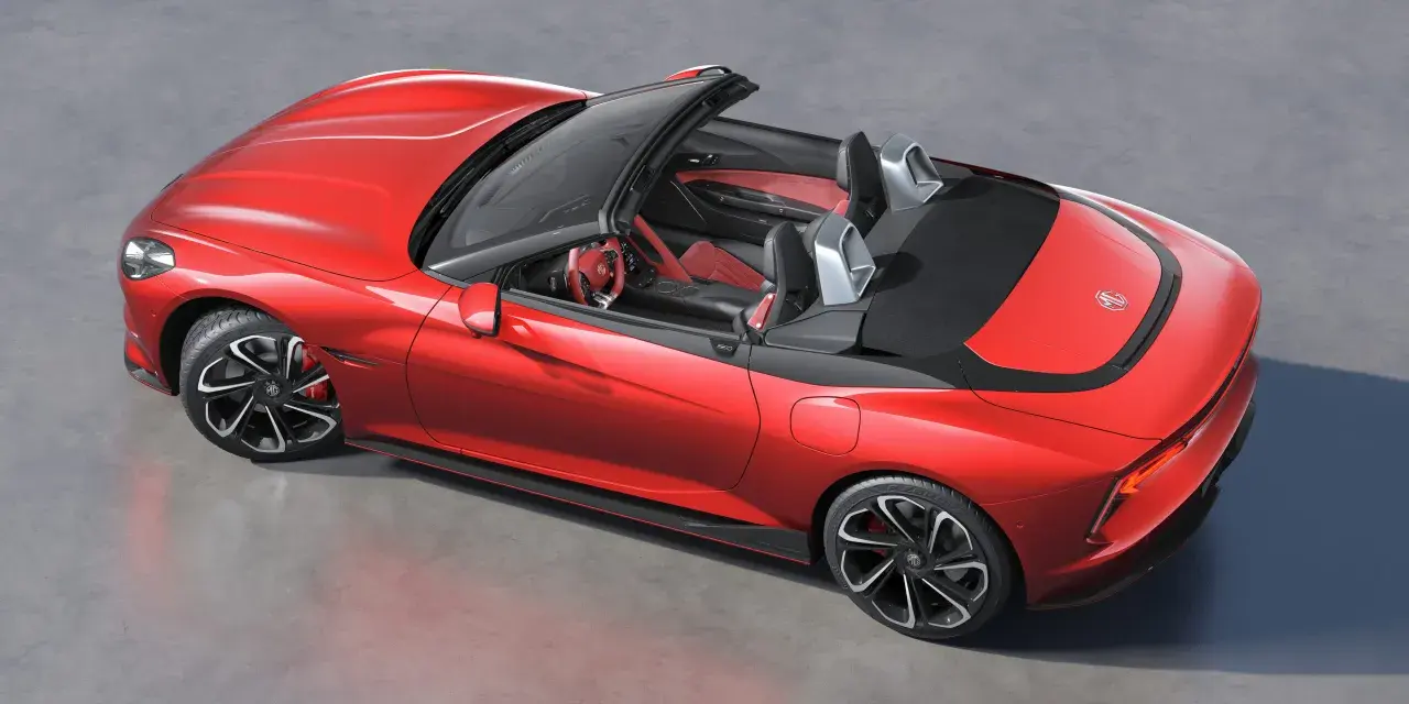Czerwony MG Roadster z otwartym dachem, sportowe wnętrze, nowoczesne felgi i aerodynamiczne linie.
