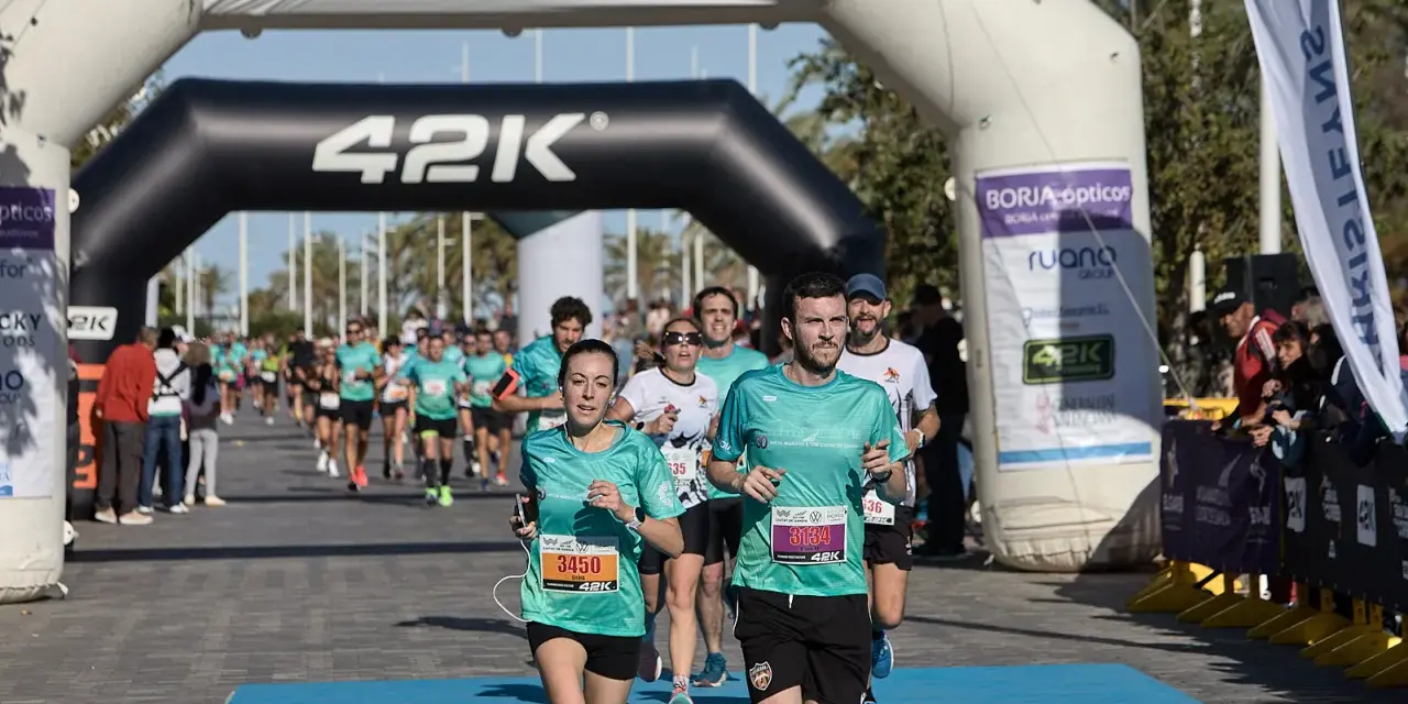 Corredores cruzan la meta de la distancia media maratón en Gandía.