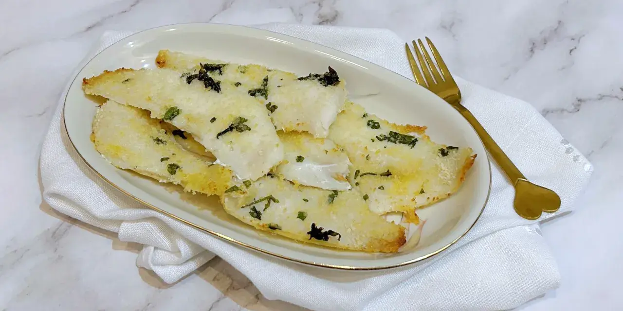 Delizioso merluzzo in friggitrice ad aria, croccante fuori e tenero dentro, guarnito con erbe aromatiche.