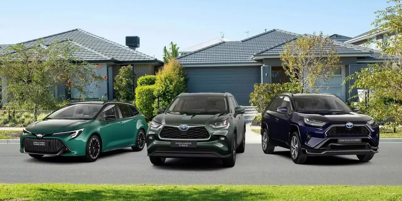Trzy modele Toyota SUV: zielony kombi, ciemnozielony Highlander Hybrid i granatowy RAV4 Plug-in Hybrid, zaparkowane przed domami.