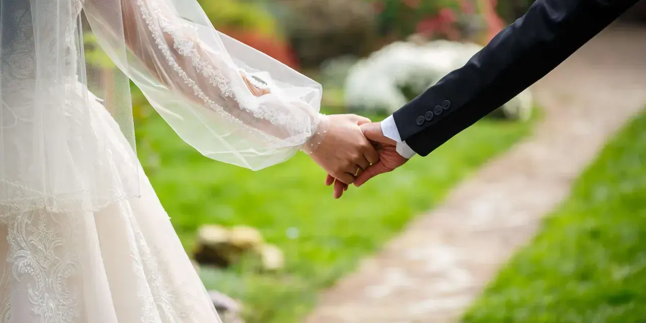 Brautpaar hält Händchen, ein Zeichen für ihren Sonderurlaub zur Hochzeit.