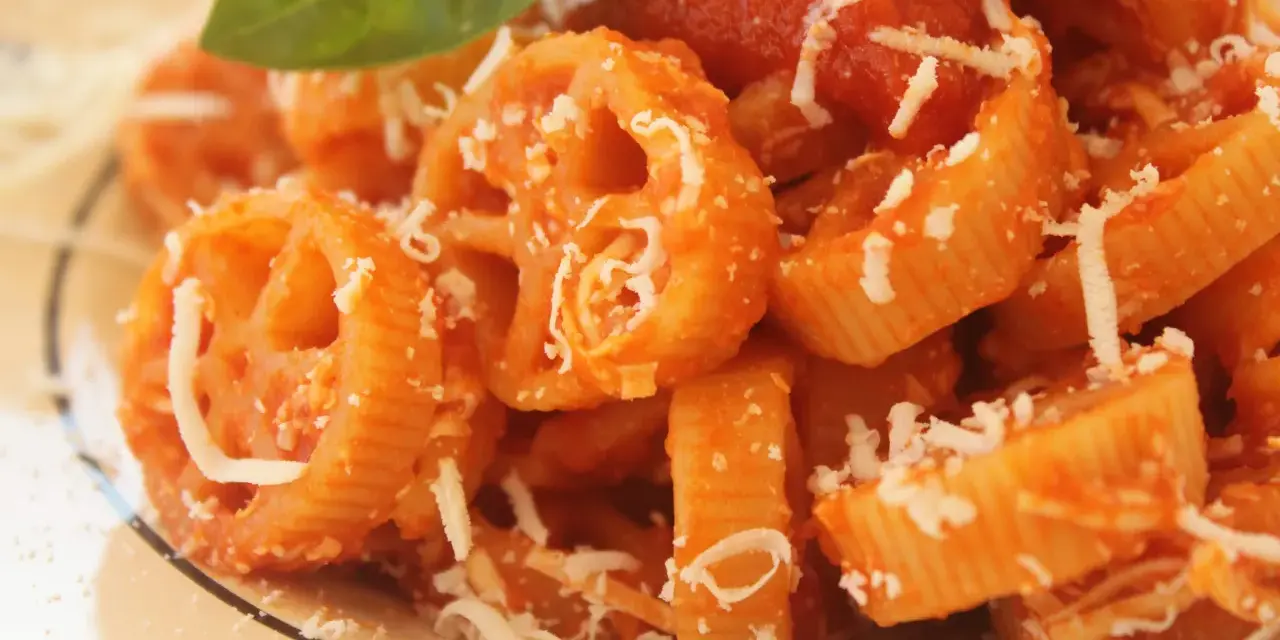 Pasta con ruote e rigatoni conditi con una ricca salsa di pomodoro Bimby, spolverata di parmigiano e guarnita con una foglia di basilico.