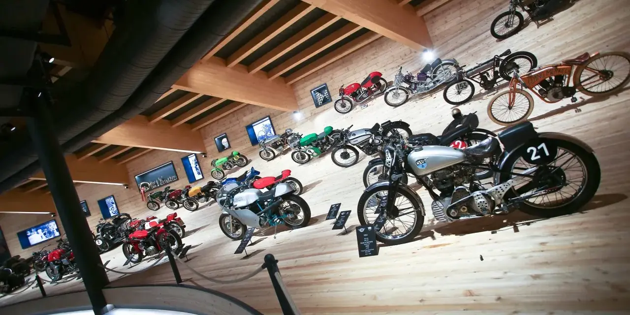 Collezione di moto d'epoca in un museo, con modelli da corsa e stradali. Un viaggio nella storia del motociclismo al museo moto passo rombo.