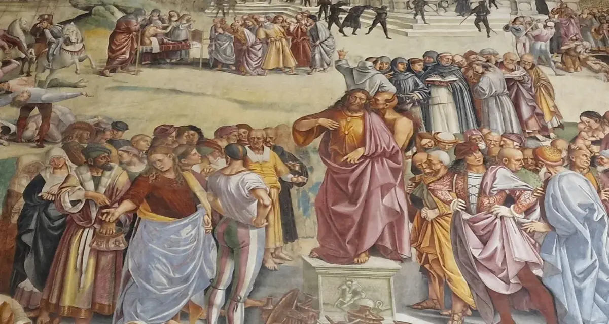 Tłum otacza Jezusa, który przemawia. Wśród tłumu widać ludzi w barwnych strojach, mnichów i żołnierzy. Czy to heretyk, kto to?