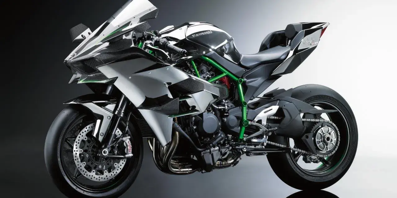Srebrno-czarny Kawasaki Ninja H2R, znany jako najszybszy motor na świecie, z zieloną ramą i karbonowymi elementami.