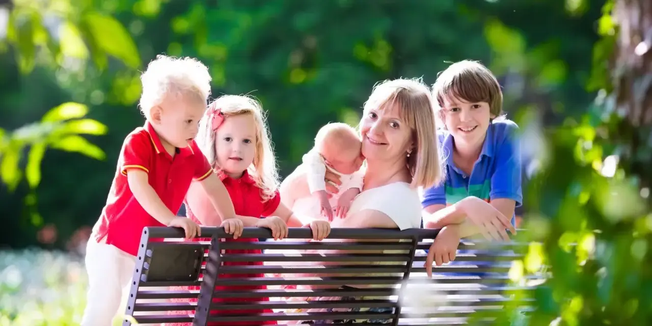 Szczęśliwa mama z czwórką dzieci, marząca o emeryturze dla matek 4 dzieci, które pracowały.