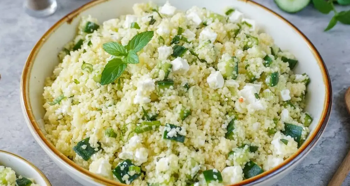 Frischer Couscous-Salat mit Gurkenwürfeln, Feta und Minze, garniert mit einer Minz-Dolde.