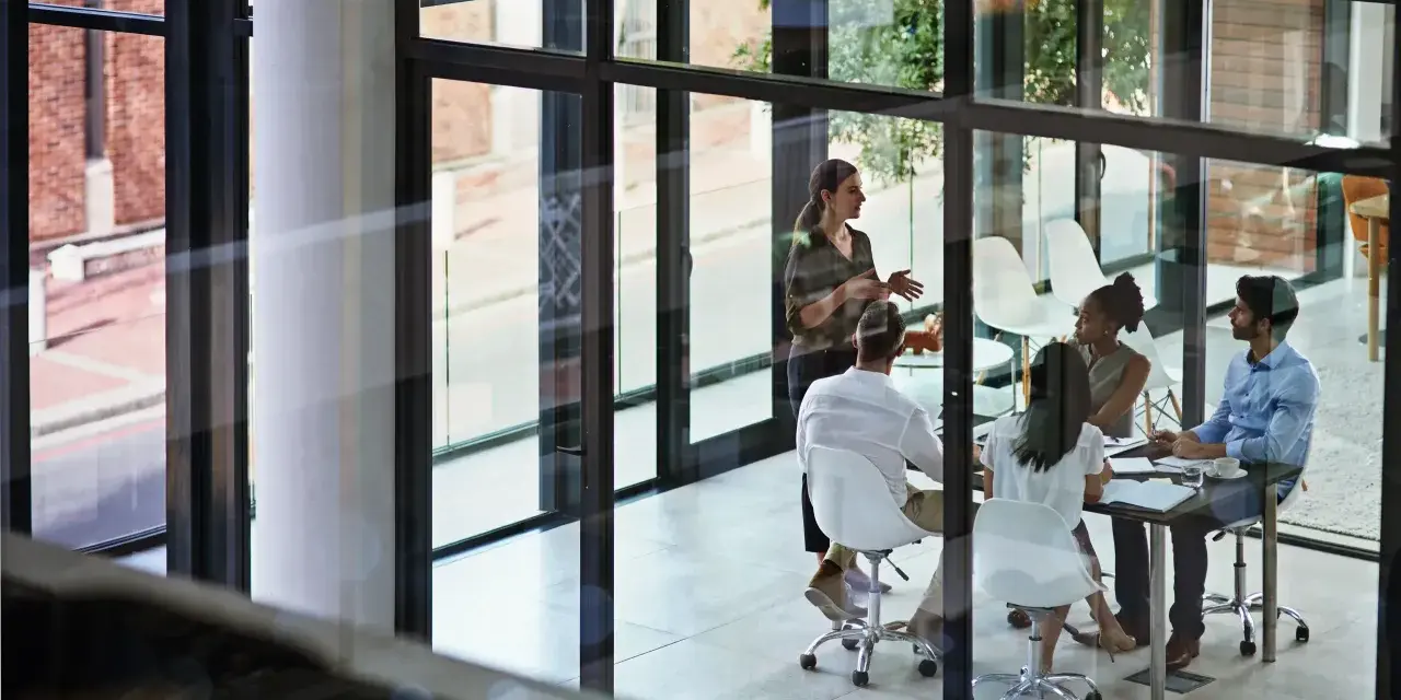 A team discusses network infrastructure solutions in a modern office meeting room.