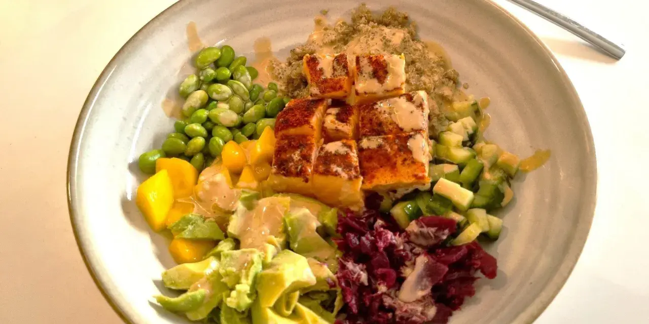 En vacker och hälsosam middagsbowl med lax, quinoa, edamamebönor, mango, avokado och rödbetor. Ett perfekt recept för en snabb och god middag.