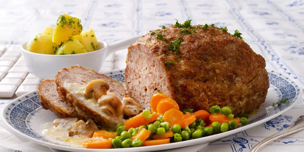 Herzhaftes Hackbraten-Mittagessen nach Omas Rezepten, serviert mit Salzkartoffeln, Pilzrahmsoße und Gemüse.