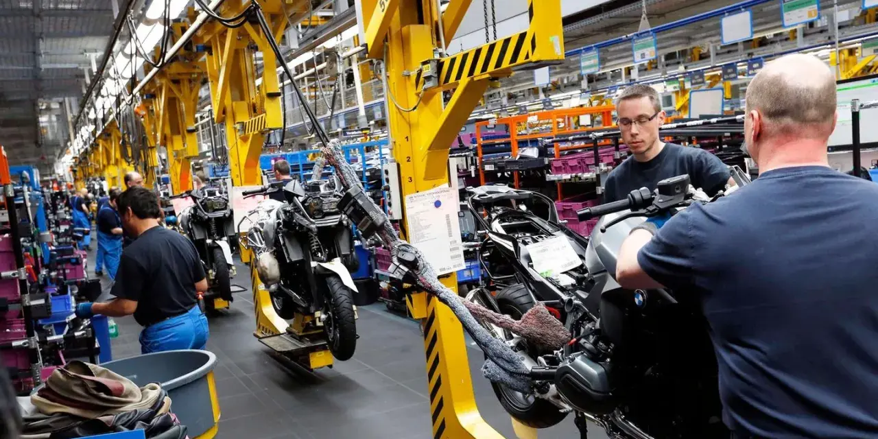 Männer arbeiten an Motorrädern in einer Fabrik. An Christi Himmelfahrt muss man anscheinend arbeiten.