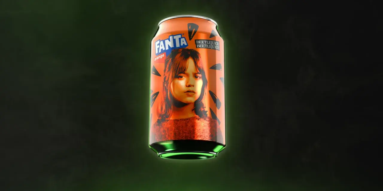 Pomarańczowa puszka Fanta z wizerunkiem dziewczyny i napisem Beetlejuice na ciemnym tle.