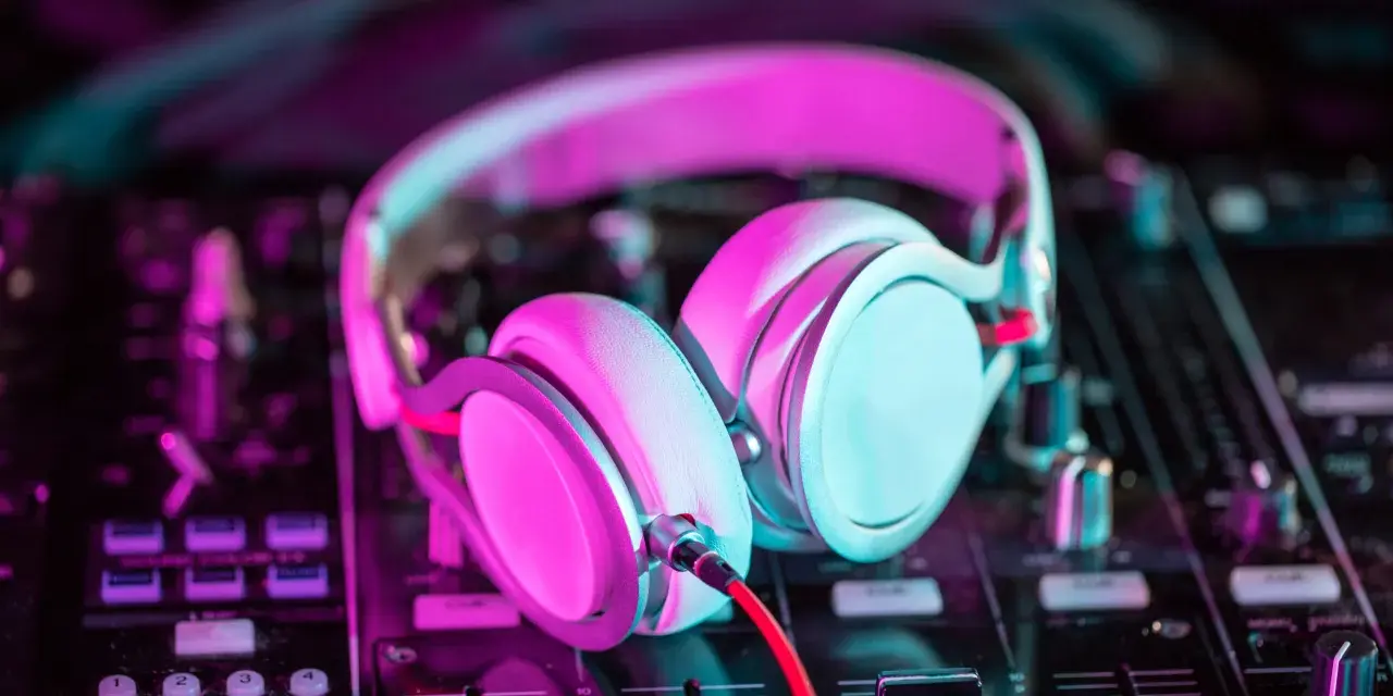 Słuchawki na mikserze, gotowe do tworzenia pulsującej muzyki elektronicznej w neonowym świetle.