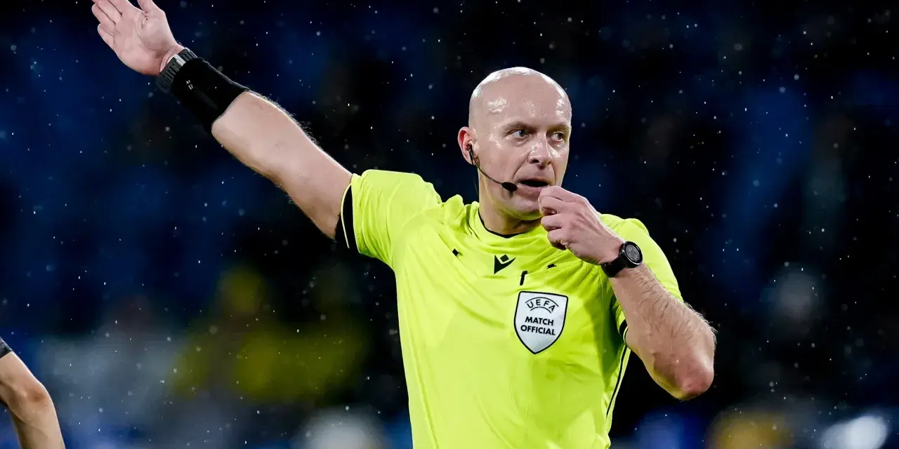 Sędzia piłkarski w żółtej koszulce z naszywką UEFA, dmucha w gwizdek. Zastanawiasz się, ile zarabia sędzia piłkarski?