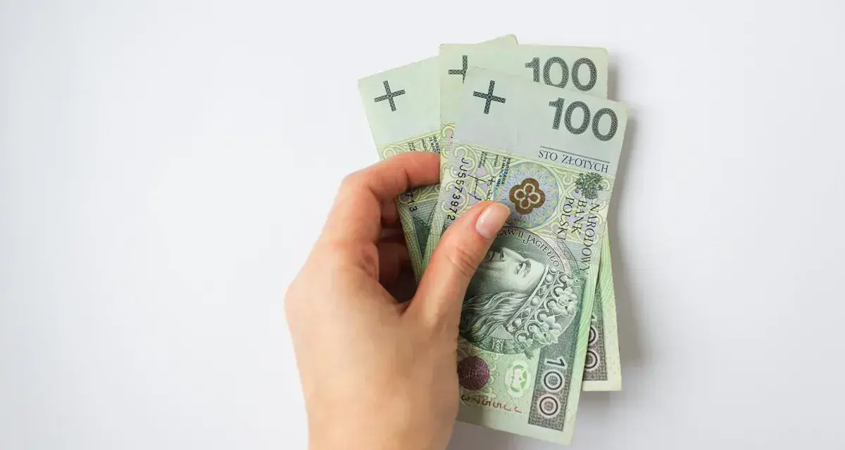 Dłoń trzyma banknoty 100 zł. To 300 zł, wystarczające na wiele przyjemności, nawet dla osoby w każdym wieku.