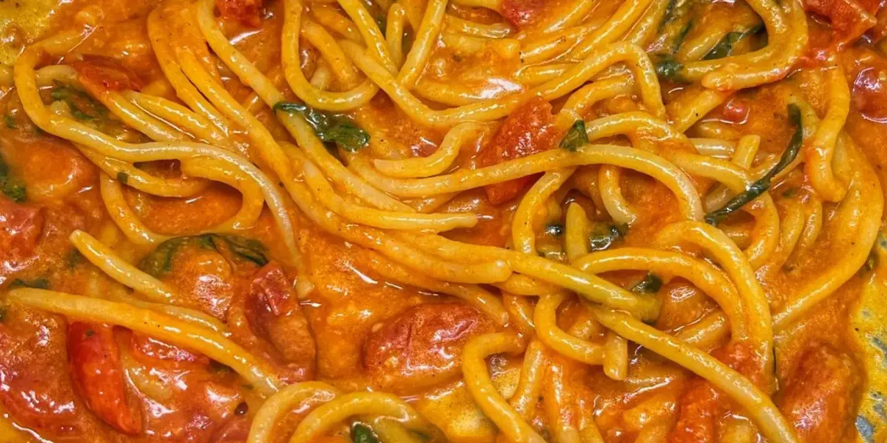 Spaghetti avvolti in un sugo cremoso di pomodoro e basilico, un invitante piatto di pasta allo scarpariello.