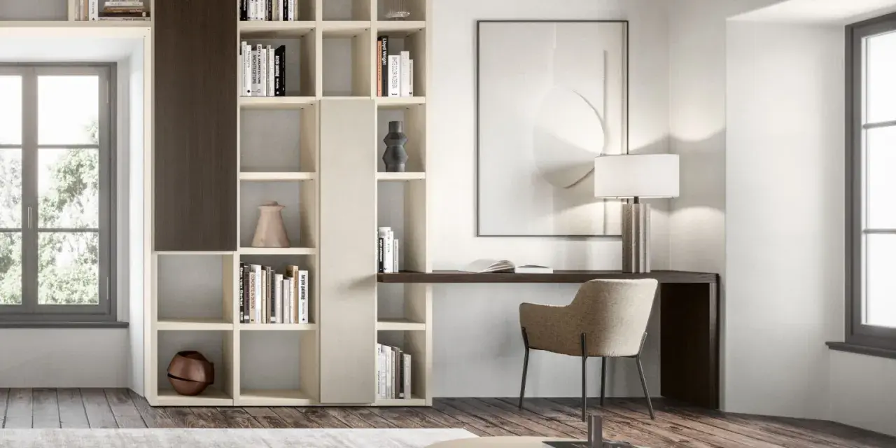 Un piccolo angolo studio in salotto, con libreria componibile, scrivania, sedia e lampada.